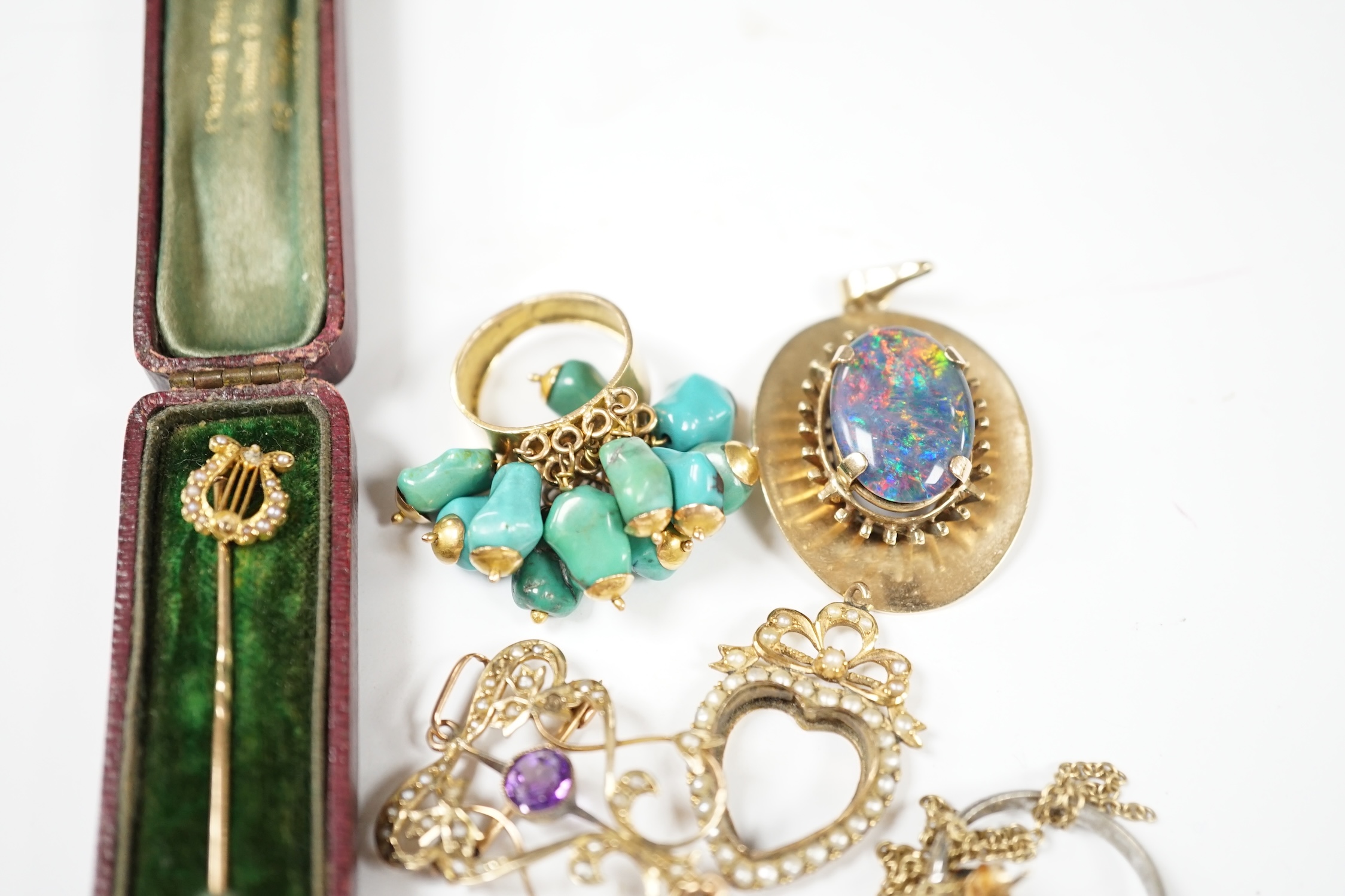 A group of jewellery including a yellow metal and seed pearl set stick pin, with lyre terminal and a 9ct and gem set pendant. Condition - poor to fair